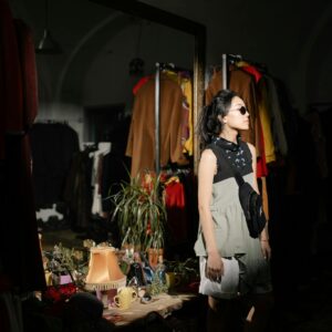 Woman in White Sleeveless Dress Standing Beside Mirror